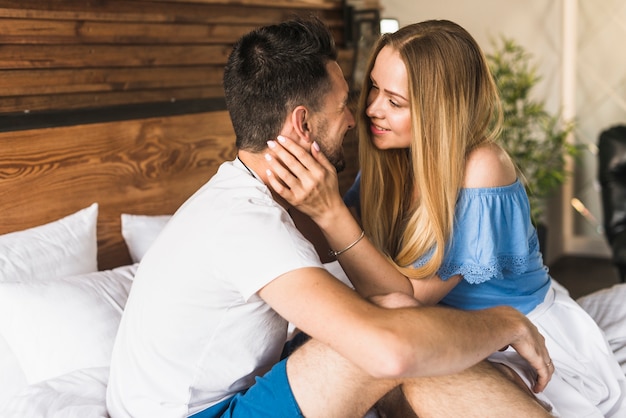 Joven pareja en la cama en casa