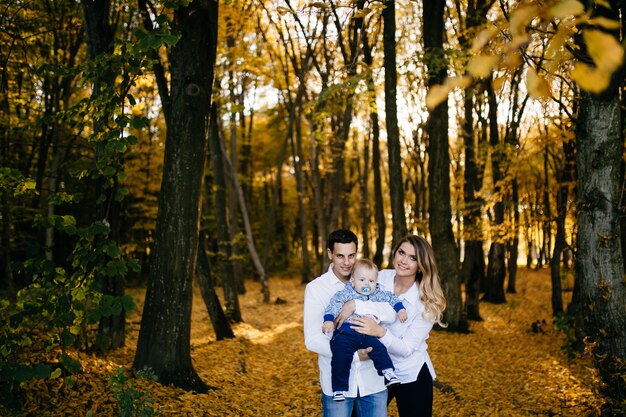 Una joven pareja camina en el bosque con un niño pequeño