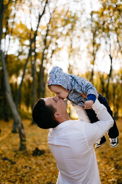 Foto gratuita una joven pareja camina en el bosque con un niño pequeño