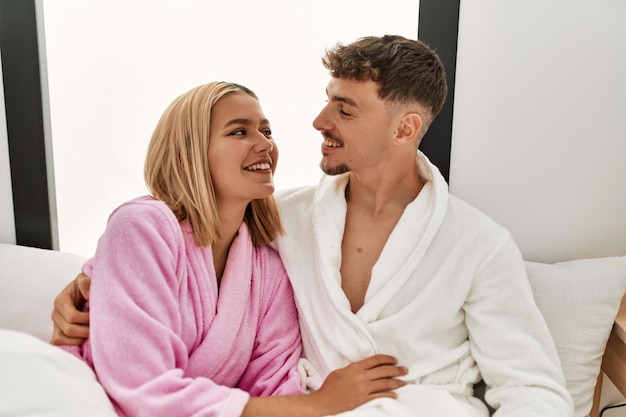 Foto gratuita joven pareja caucásica sonriendo feliz y abrazándose en la cama en casa