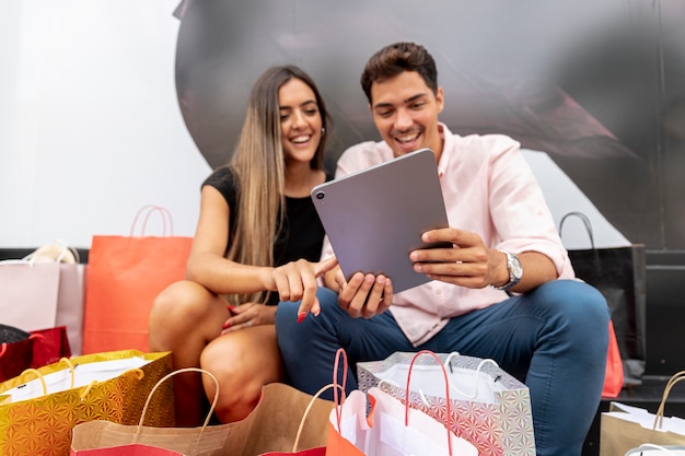 Joven pareja de compras con tableta