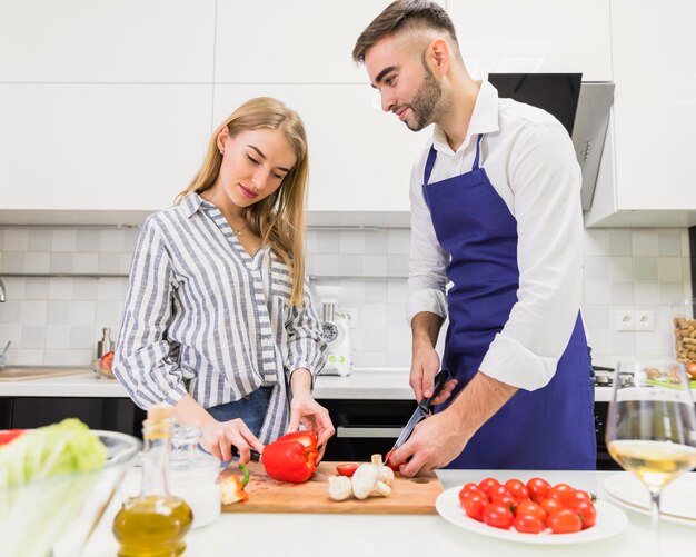 Joven pareja cortar verduras para ensalada a bordo