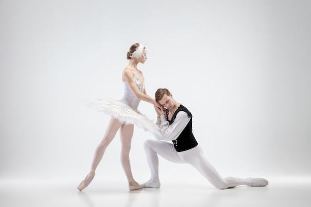 Joven pareja elegante de bailarines de ballet sobre fondo blanco de estudio