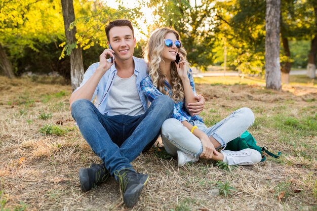 Joven pareja elegante sentada en el parque, familia feliz hombre y mujer juntos