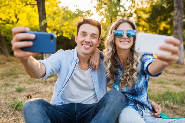 Joven pareja elegante sentada en el parque, familia feliz hombre y mujer juntos