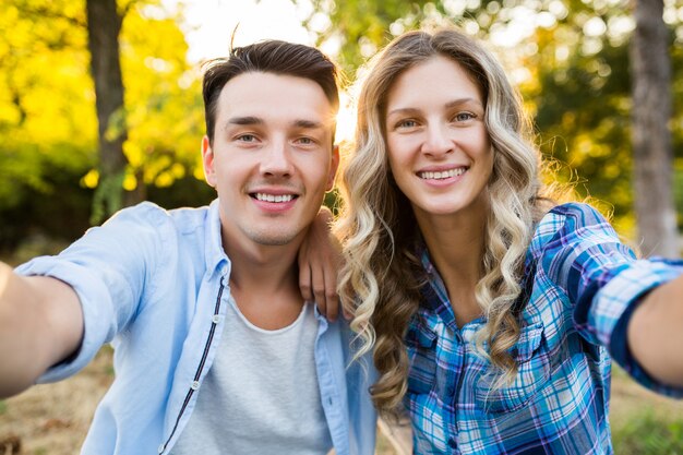 Joven pareja elegante sentada en el parque, familia feliz hombre y mujer juntos