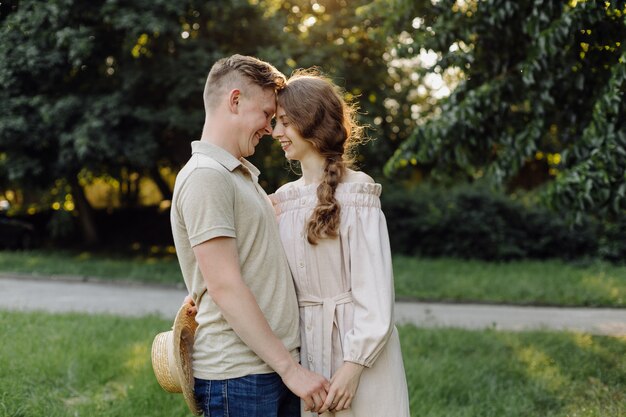 Joven pareja enamorada al aire libre. Impresionante sensual retrato al aire libre de la joven pareja de moda elegante posando en verano en el campo