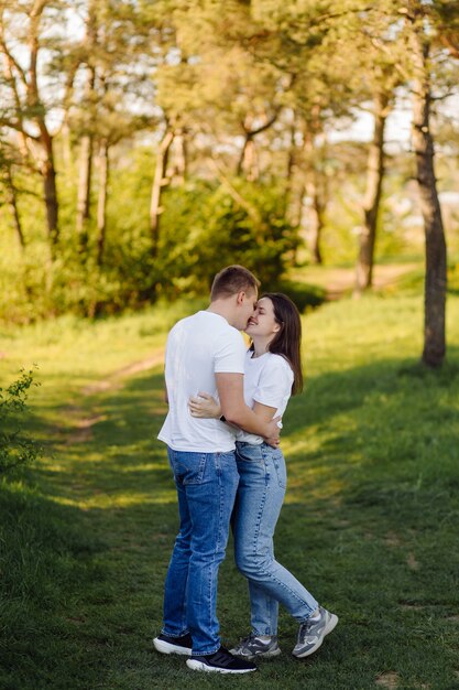 Una joven pareja enamorada camina por el bosque, pasando un buen rato juntos