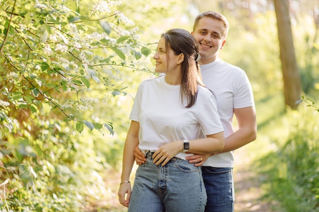 Una joven pareja enamorada camina por el bosque, pasando un buen rato juntos