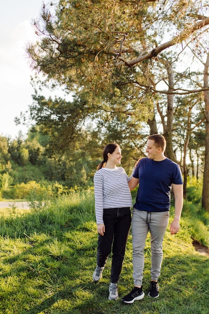 Una joven pareja enamorada camina por el bosque, pasando un buen rato juntos