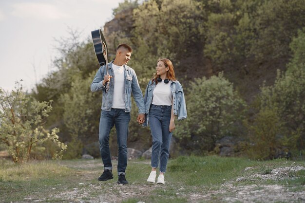 Joven pareja enamorada, novio sosteniendo una guitarra