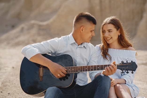 Joven pareja enamorada, novio tocando la guitarra