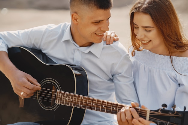 Joven pareja enamorada, novio tocando la guitarra