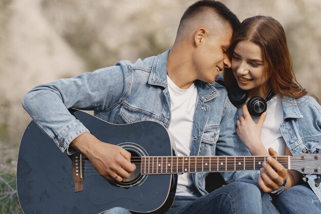 Joven pareja enamorada, novio tocando la guitarra