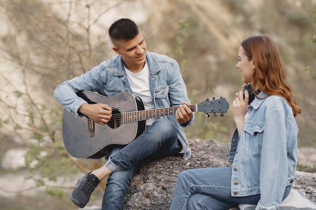 Joven pareja enamorada, novio tocando la guitarra