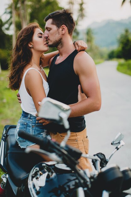 Joven pareja de enamorados cerca de una motocicleta