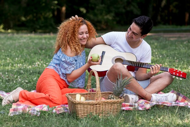 Joven pareja de enamorados en manta de picnic