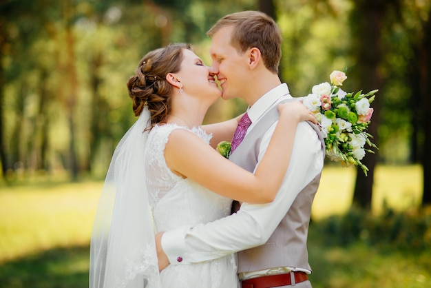 Joven pareja de enamorados, novio y novia en vestido de novia en la naturaleza. Boda.