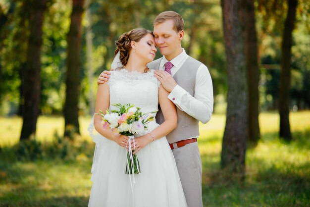 Joven pareja de enamorados, novio y novia en vestido de novia en la naturaleza. Boda.