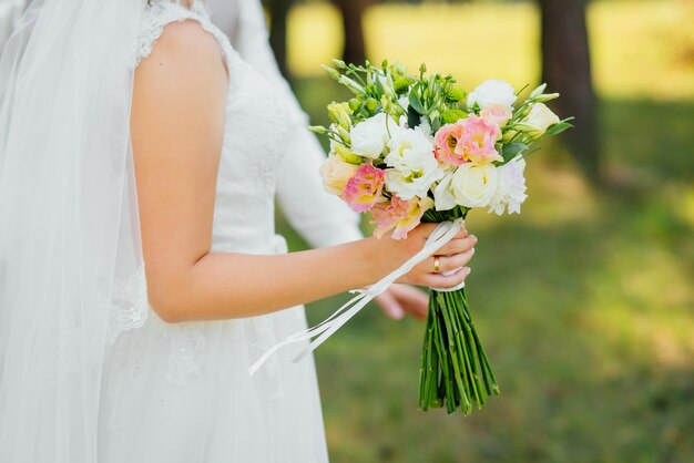 Joven pareja de enamorados, novio y novia en vestido de novia en la naturaleza.