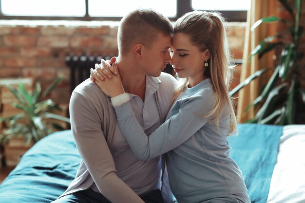 Joven pareja de enamorados pasar tiempo juntos. Hermosa mujer y hombre guapo teniendo momentos íntimos en casa