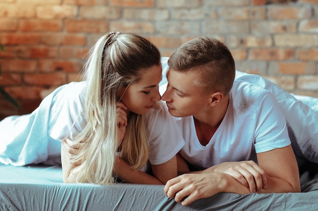 Joven pareja de enamorados pasar tiempo juntos. Hermosa mujer y hombre guapo teniendo momentos íntimos en casa