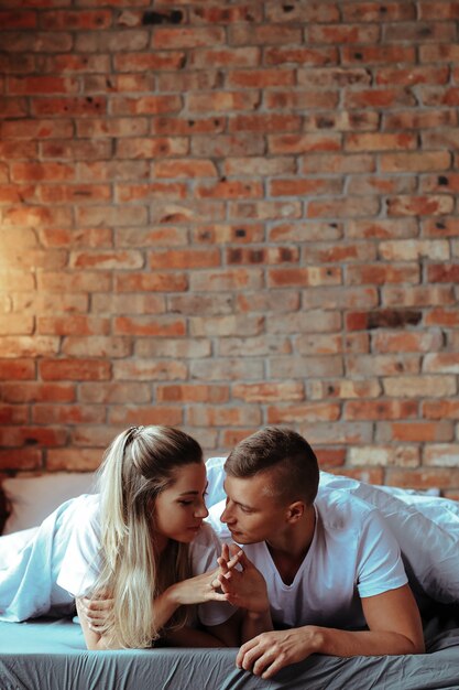 Joven pareja de enamorados pasar tiempo juntos. Hermosa mujer y hombre guapo teniendo momentos íntimos en casa