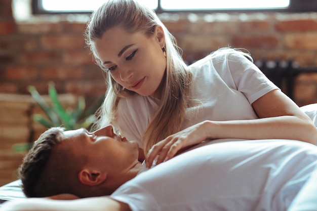 Joven pareja de enamorados pasar tiempo juntos. Hermosa mujer y hombre guapo teniendo momentos íntimos en casa