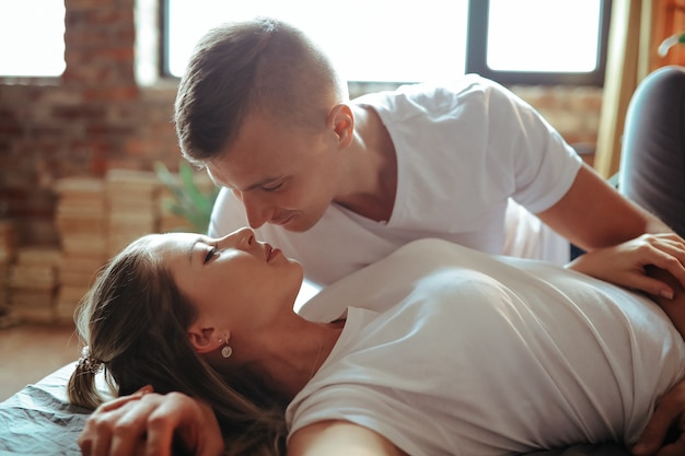 Foto gratuita joven pareja de enamorados pasar tiempo juntos. hermosa mujer y hombre guapo teniendo momentos íntimos en casa