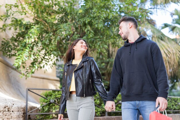 Joven pareja feliz caminando en la calle