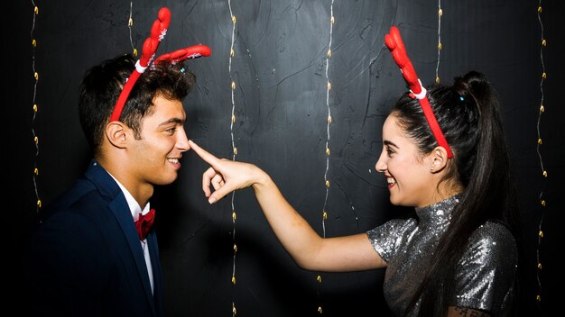 Joven pareja feliz con cintas de astas de ciervo rojo