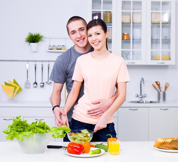 Joven pareja feliz cocinando juntos en la cocina