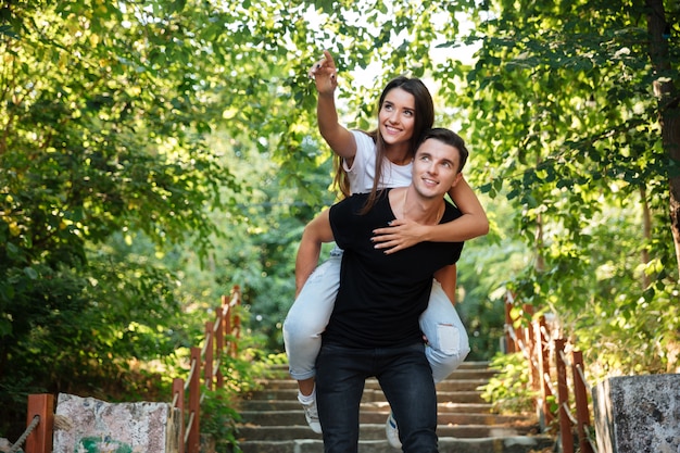 Joven pareja feliz disfrutando de caballito en el parque