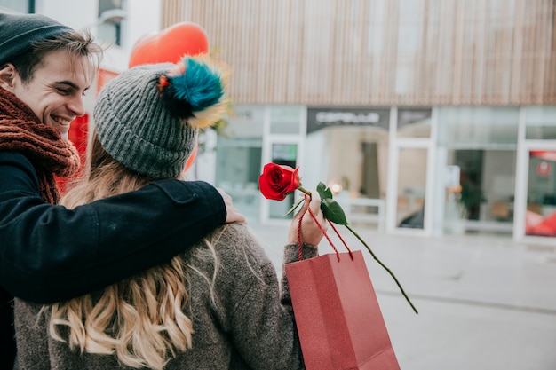 Foto gratuita joven pareja feliz con rosa