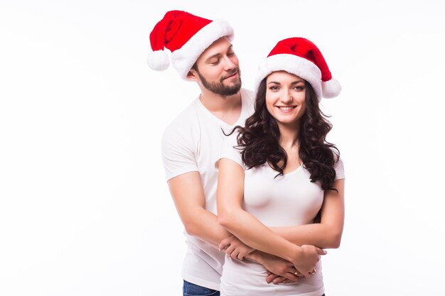 Joven pareja feliz con sombreros de Navidad. Aislado sobre fondo blanco