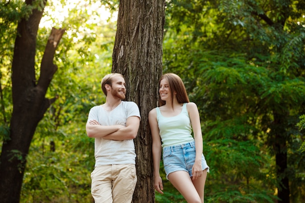 Foto gratuita joven pareja hermosa descansando, caminando en el parque, sonriendo, regocijándose.