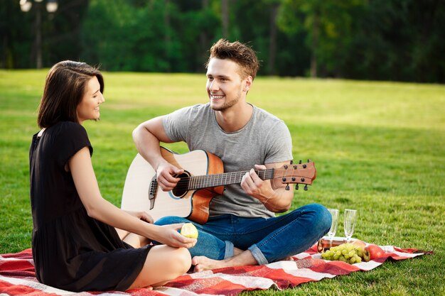 Joven pareja hermosa descansando en el parque