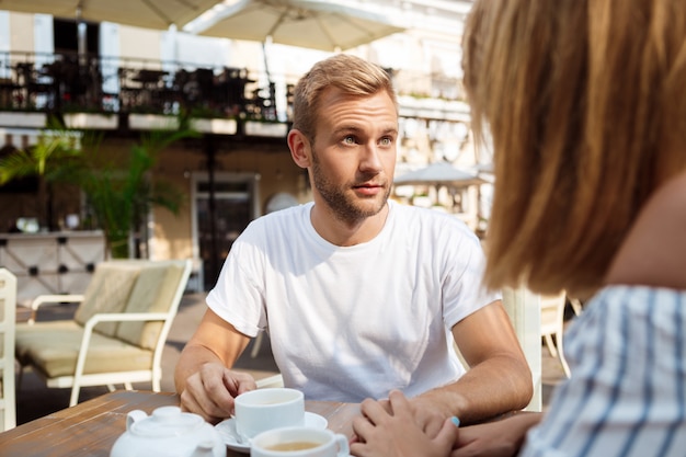 Joven pareja hermosa pelea, sentado en la cafetería.