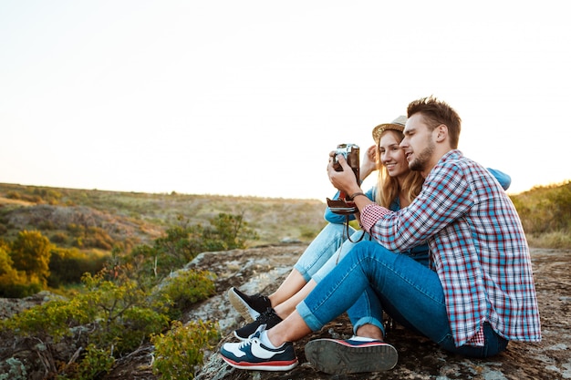 Joven pareja hermosa sonriendo, tomando foto del paisaje del cañón