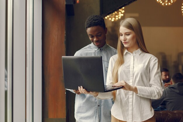 Joven pareja internacional trabajando juntos y usa la computadora portátil