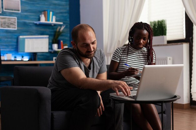 Joven pareja interracial pagando impuestos por economía financiera