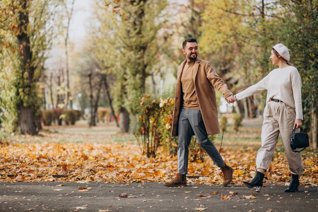 Joven pareja junto en un parque de otoño