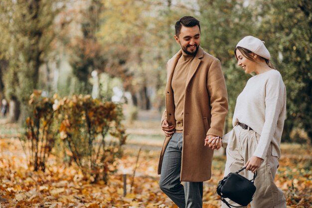 Joven pareja junto en un parque de otoño