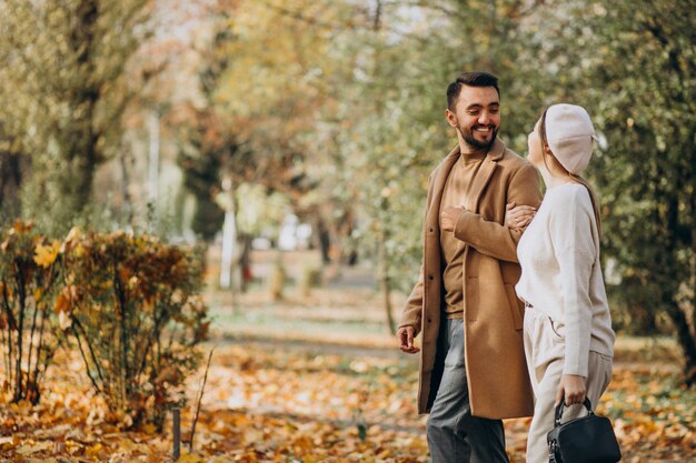 Joven pareja junto en un parque de otoño