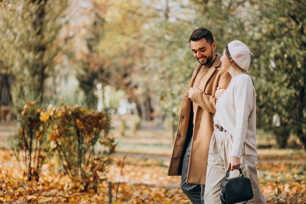 Joven pareja junto en un parque de otoño