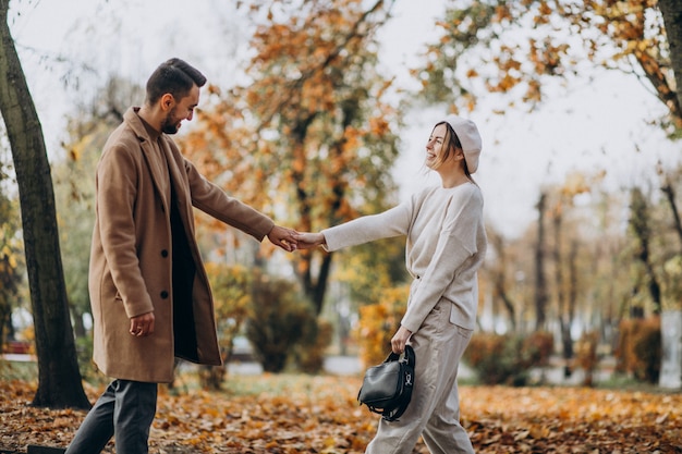 Joven pareja junto en un parque de otoño