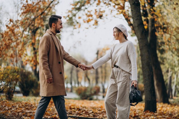 Joven pareja junto en un parque de otoño