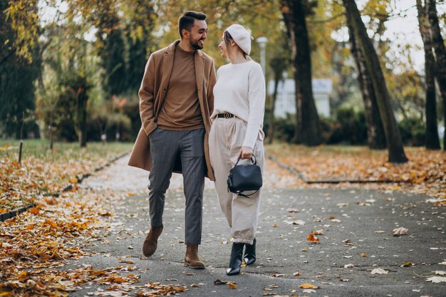 Joven pareja junto en un parque de otoño