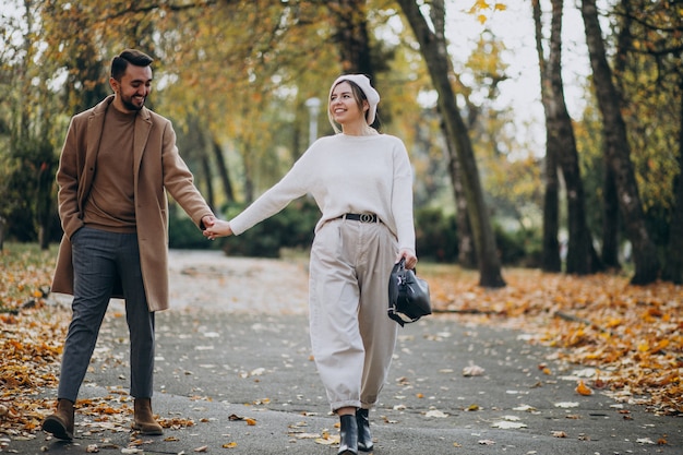 Joven pareja junto en un parque de otoño