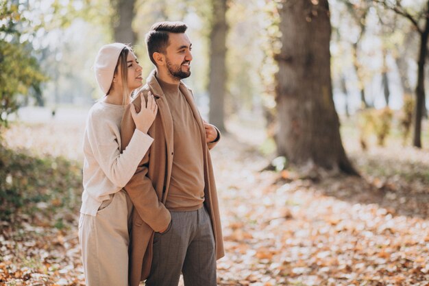 Joven pareja junto en un parque de otoño